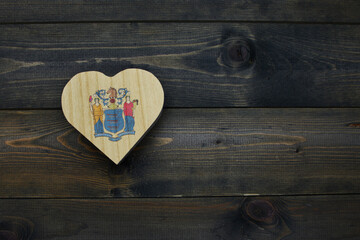 wooden heart with national flag of new jersey state on the wooden background.