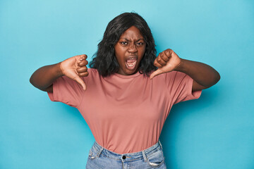 Young african american curvy woman showing thumb down and expressing dislike.