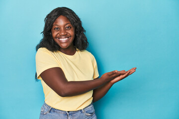 Young african american curvy woman holding a copy space on a palm.