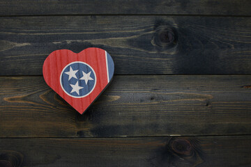wooden heart with national flag of tennessee state on the wooden background.