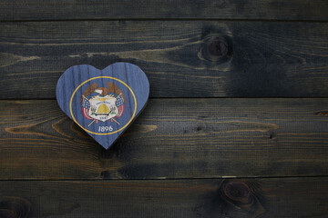 wooden heart with national flag of utah state on the wooden background.