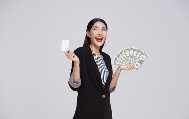 Happy asian business woman showing, presenting credit card and money dollars, smiling and laughing, isolated on white studio background.