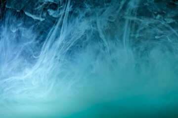 clouds of blue smoke on a black background, clouds of paint in water, aquarium, abstract...