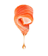 Twisted salmon slice with falling fat drop close up isolated on a white background