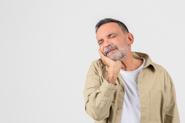 Mature man with toothache grimacing in pain