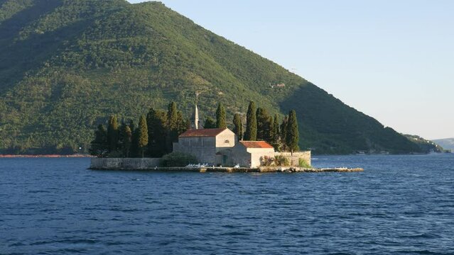 St.George Catholic monastery, Bay of Kotor, Montenegro, a view of a small island with an old building and a church. Shooting video from a moving boat.