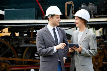 businesspeople talking and checking train on construction site
