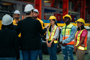 Team engineers and foreman stack hand and shake hands to show success at factory machines. Worker...