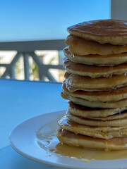 Close up of tall pancake stack with honey drips