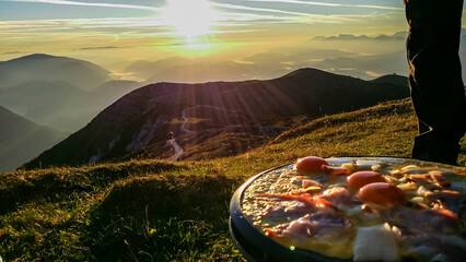 Cocking ham and eggs during sunrise on top of Dobratsch, Villach Alps, Carinthia, Austria, Europe....
