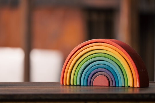 Brightly coloured wooden rainbow learning puzzle in nature-based playground environment