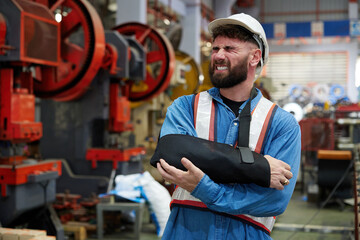 worker or engineer wearing bandages splint, pain in elbow and ache in arm from hard work in the factory