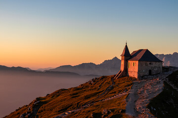 Scenic sunrise view of chapel Maria am Stein on top of mountain peak Dobratsch, Villacher Alps,...