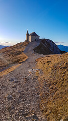 Scenic hiking trail at sunrise to chapel Maria am Stein on top of mountain peak Dobratsch,...