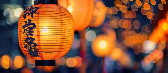 A Japanese-style close-up shot of orange-yellow glowing lanterns at night hanging by the roadside with a blurred bokeh background. Space to add text.