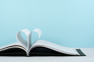 Old open hardback book, page decorate into a heart shape for love in Valentine's. love with open book heart.