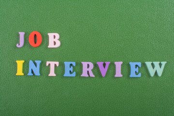 JOP INTERVIEW word on green background composed from colorful abc alphabet block wooden letters,...