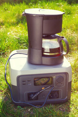 The portable power battery with electrical drip coffee maker. Morning aroma coffee in camp with sunlight. - 779982026