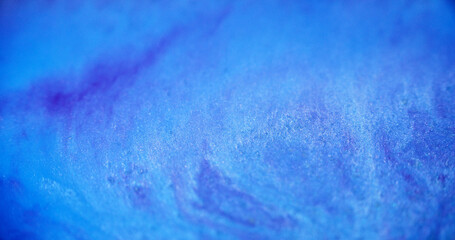 Liquid glitter wave. Acrylic paint blend. Defocused blue purple color shiny shimmer sand particles...