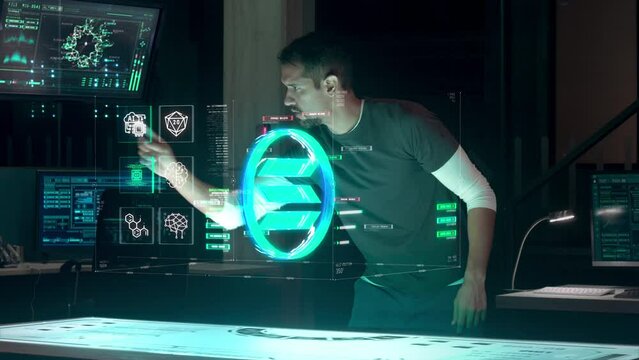Independent and Young Male Blockchain Engineer and IT Developer works in Modern Research Facility using Augmented Holographic Technology interacting with Solana Network Protocol.