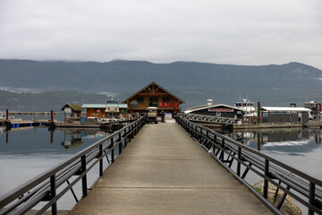 Wooden pier at a mountains leading to small harbor - 779988033