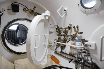 Interior of a white hyperbaric chamber with airlock