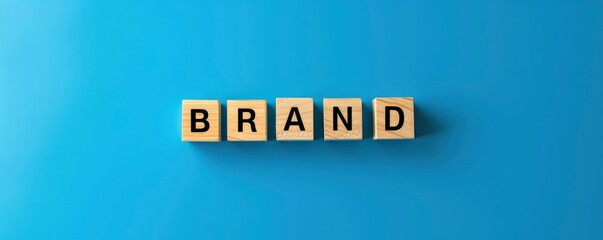 Wooden blocks with text BRAND on a blue background, a business concept for marketing or advertising a brand name product.