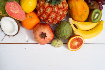 Summer mix of tropical fruits over white wooden background