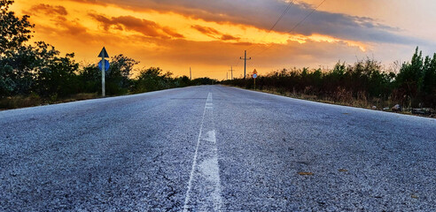 Concept shot of the road in the rural village. Dramatic sunset. Nature