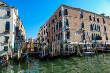 Group of gondolas moored in channel Canal Grande near the famous Rialto bridge in city of Venice, Veneto, Northern Italy, Europe. Venetian architectural landmarks. Romantic vacation