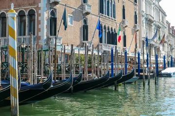 Papier Peint photo autocollant Pont du Rialto Group of gondolas moored in channel Canal Grande near the famous Rialto bridge in city of Venice, Veneto, Northern Italy, Europe. Venetian architectural landmarks. Romantic vacation