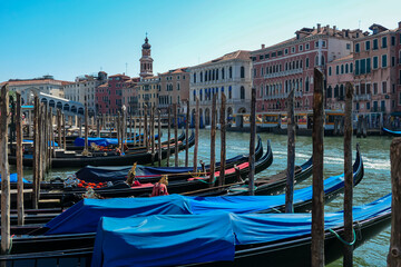 Fototapeta na wymiar Group of gondolas moored in channel Canal Grande near the famous Rialto bridge in city of Venice, Veneto, Northern Italy, Europe. Venetian architectural landmarks. Romantic vacation