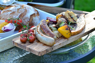 background of food prepared on outdoor grill with open fire, sausages, vegetables, steak, different...