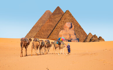 A woman tourist riding a camel with a multicolored umbrella - Camels in Giza Pyramid Complex -...