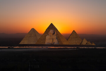 Giza pyramid Complex by the Nile at amazing sunset - Fishermen casting their fishing nets on a boat in Nile river at amazing sunset - Egypt