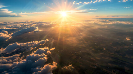A breathtaking aerial view captured from a plane flying high above the earth, with majestic clouds swirling below and the sun casting golden rays across the horizon - obrazy, fototapety, plakaty