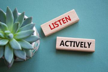 Listen actively symbol. Wooden blocks with words Listen actively. Beautiful grey green background...