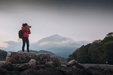 photographer aand traveler woman with backpack in the nature 