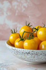 Yellow tomatos in plate on pink background. Aesthetic summer vibe vegetables wallpaper.