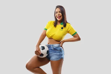 Foto op Plexiglas  Brazilian girl celebrating with the soccer ball and national flag. © Igor Link
