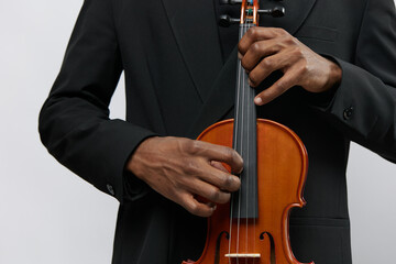Closeup of a professional musician in formal attire playing a violin with passion on a clean white...