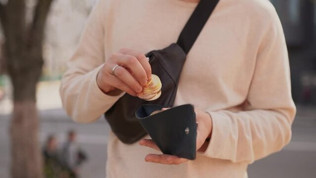 A crypto trader investor takes out and holds gold coins of the digital crypto currency Bitcoin from his wallet. BTC in real life in the future. Exchange and trading of money and assets.