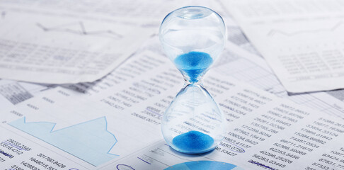 Best time for investment. Hourglass, financial charts and calculator.