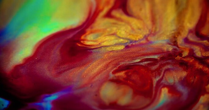 Glitter paint drip. Ink flow. Liquid marble. Blur red yellow purple cyan green color golden glow shiny particles fluid blend motion abstract art background.