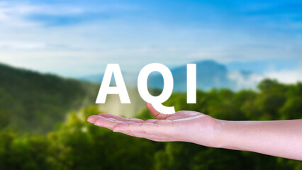 AQI, Abbreviation of air quality index, hand holding AQI on nature background, environment concept.