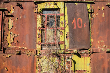 Rusty and peeling paint wall of abandoned neglected railroad car closeup as colorful grunge...