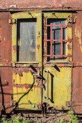 Rusty and peeling paint wall of abandoned neglected railroad car closeup as colorful grunge...