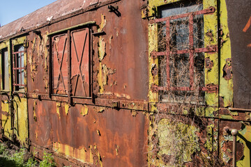 Rusty and peeling paint wall of abandoned neglected railroad car closeup as colorful grunge...