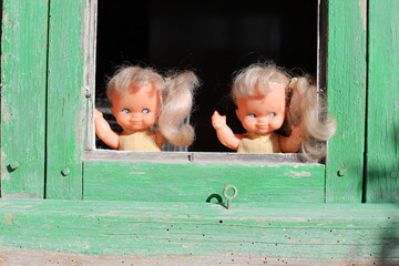 Spooky twin sister dolls looking through the window