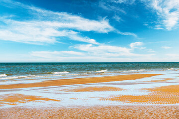 Tide waves on tropical beach sand and blue ocean